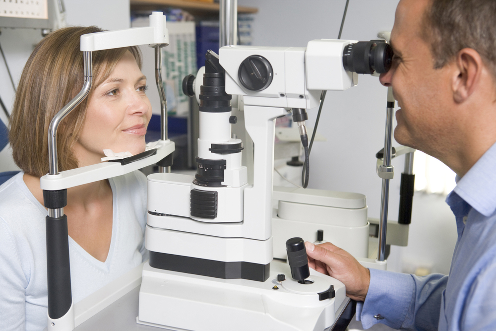 woman receiving an eye exam from her eye doctor